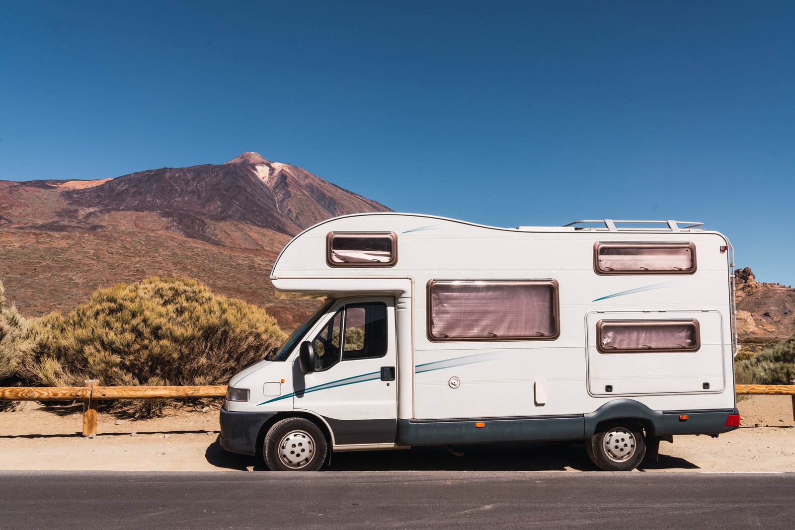 camper-van-on-road-near-hill-and-blue-sky.jpg